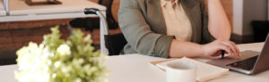 person at desk on phone and laptop